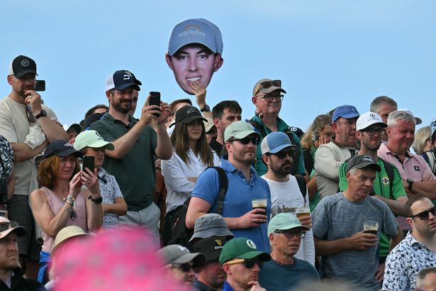 A facemask of England's Matthew Fitzpatrick is waved in the crowd