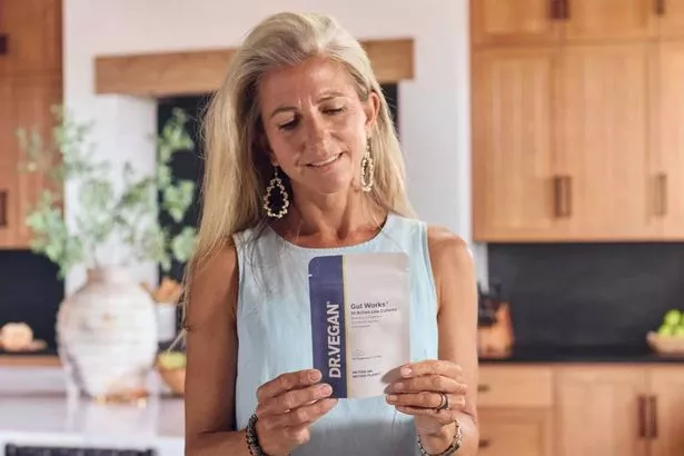 A woman reading the pack of a packet of dietary supplements.