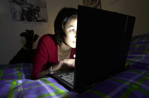 Teenager using the internet on her laptop