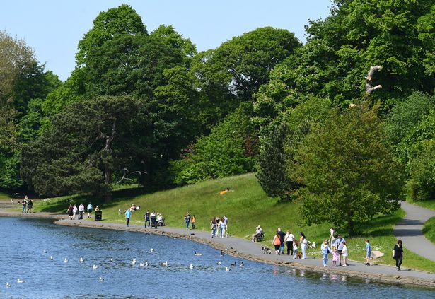 People enjoying a walk around the lake in Sefton Park