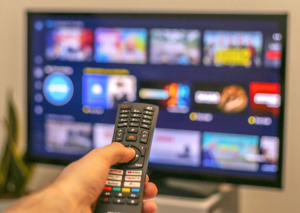 Person holding a TV remote