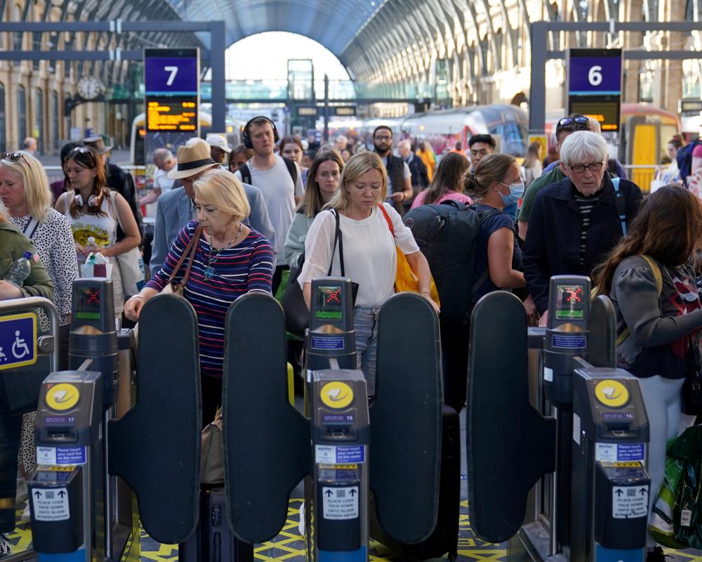 People leaving the platform through the ticket barriers at London King's Cross station