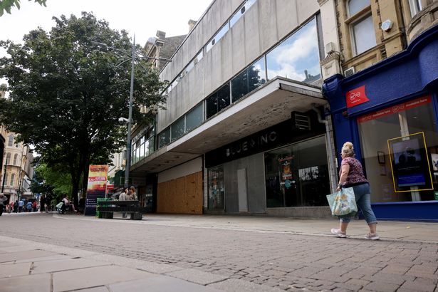 The image shows further boarded up stores in Newport city centre where there are few shoppers
