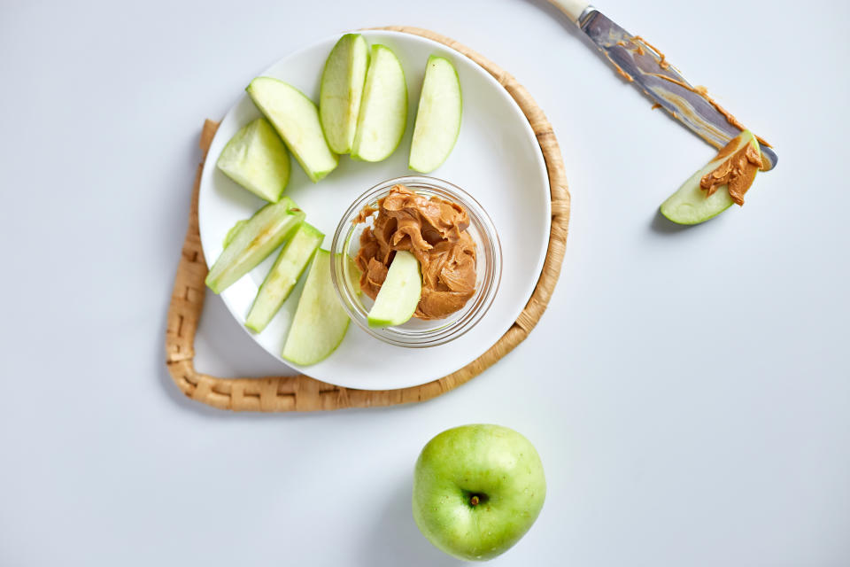 Green slices apples with peanut butter on white background, healthy snack, nutrition food, diet