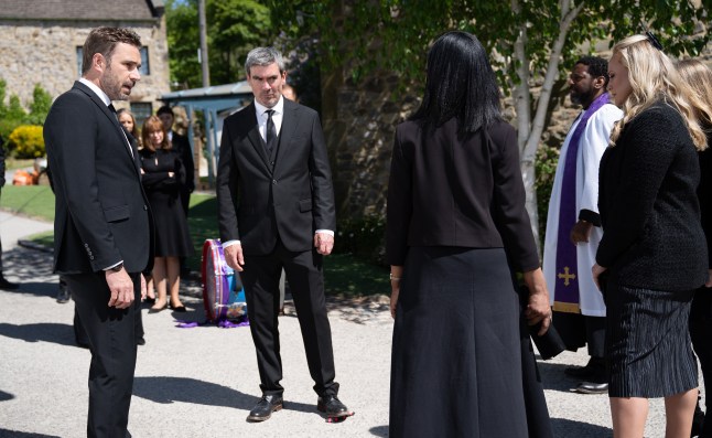 John and Cain argue with Cara and Tracy outside the church in Emmerdale