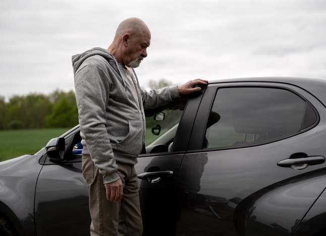 Bear stands by his car in Emmerdale