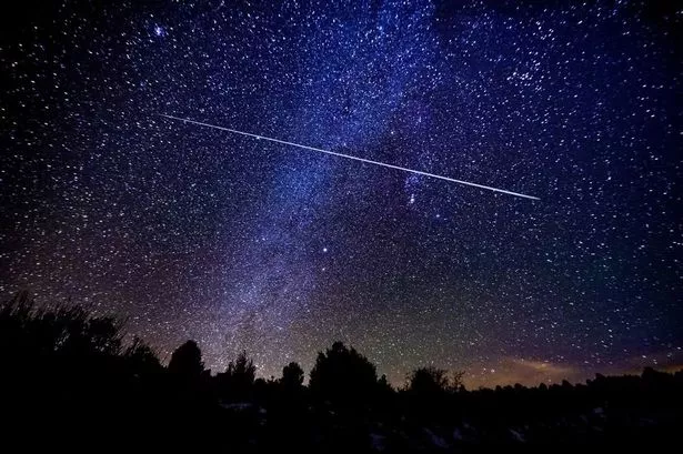 A photograph of a shooting star in the sky