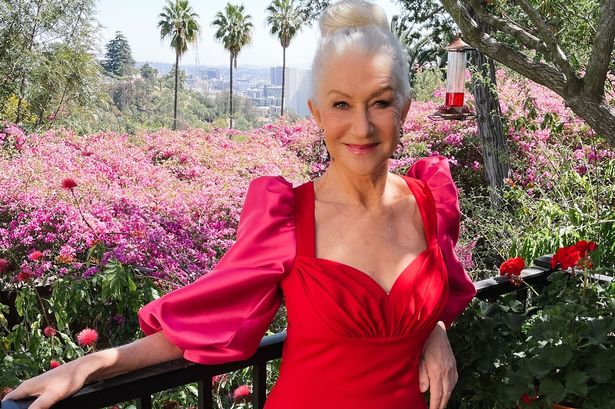 Helen Mirren in red dress in flower garden