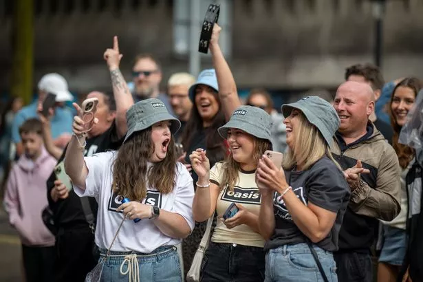 Oasis fans cheer in the street ahead of the Oasis Live '25 Tour at the Principality Stadium on July 5, 2025 in Cardiff, Wales