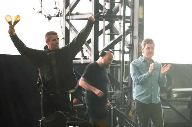 Liam and Noel Gallagher arrive on stage at the Principality Stadium in Cardiff on Friday night (July 4)