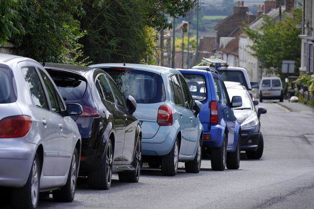Row of parked cars in street in town centre