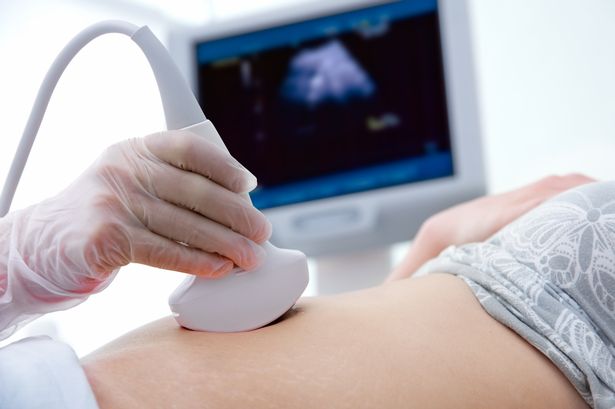 Pregnant woman getting ultrasound from doctor