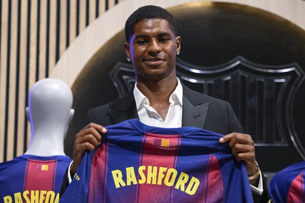 English forward Marcus Rashford holds up a Barcelona shirt with his name on it 