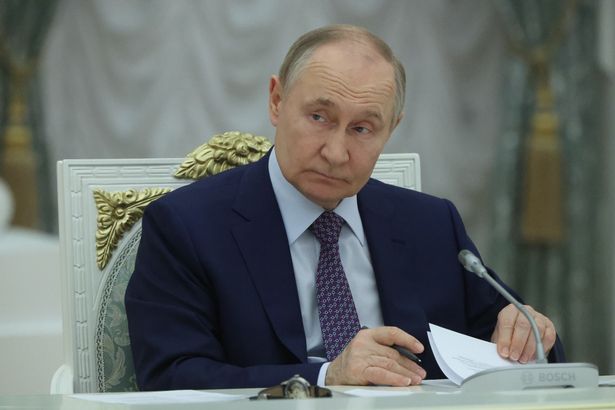Putin sifting through papers at his desk