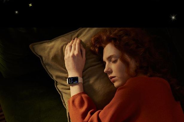A woman asleep in bed, wearing the Samsung Galaxy Smart Watch