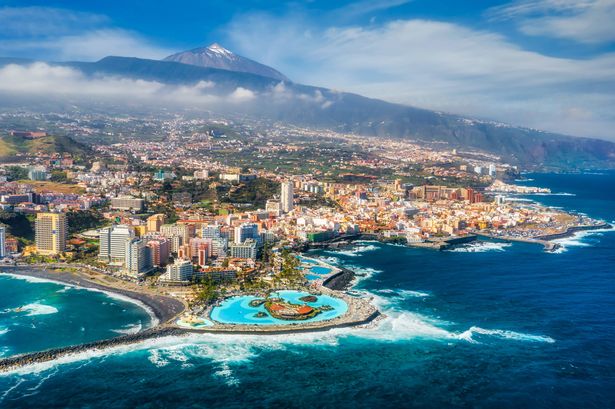 aerial landscape of the city of Puerto de la Cruz, in Tenerife. Mountain landscape, beach, and city with Mount Teide in the background, the highest volcano in Spain