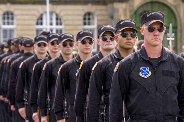 A line of US Air Force personnel, all wearing caps and aviator sunglasses