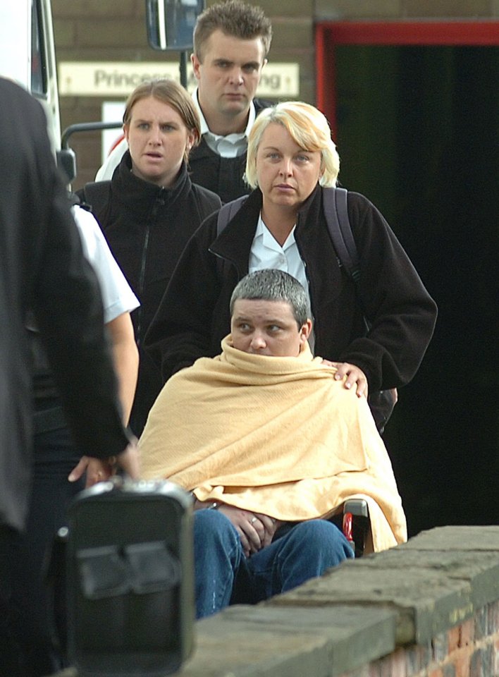 Ian Huntley being escorted from Pinderfield Hospital in a wheelchair.