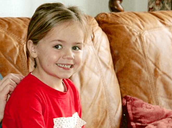 Photo of a young girl sitting on a couch.