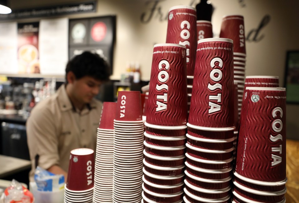 Milk being poured into a Costa Coffee cup, creating latte art.