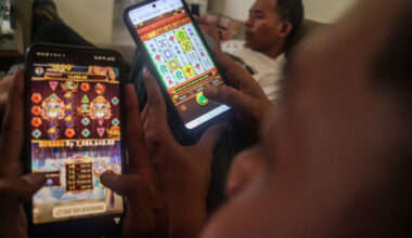 People look at online gambling websites on a smartphone in Bogor, West Java, on May 30, 2024.