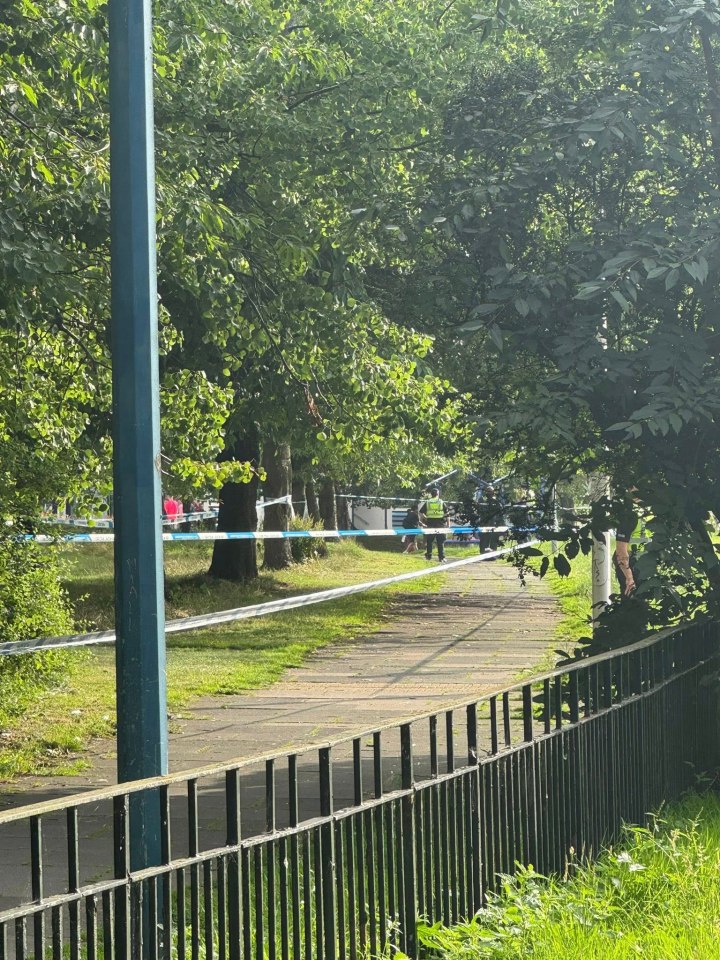 Police tape surrounds a park path.