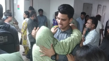 Rohan with his mother at the Burn Institute, as his sister receives treatment inside. Photo was taken at the burn institute on 21 July by Ashraful Haque