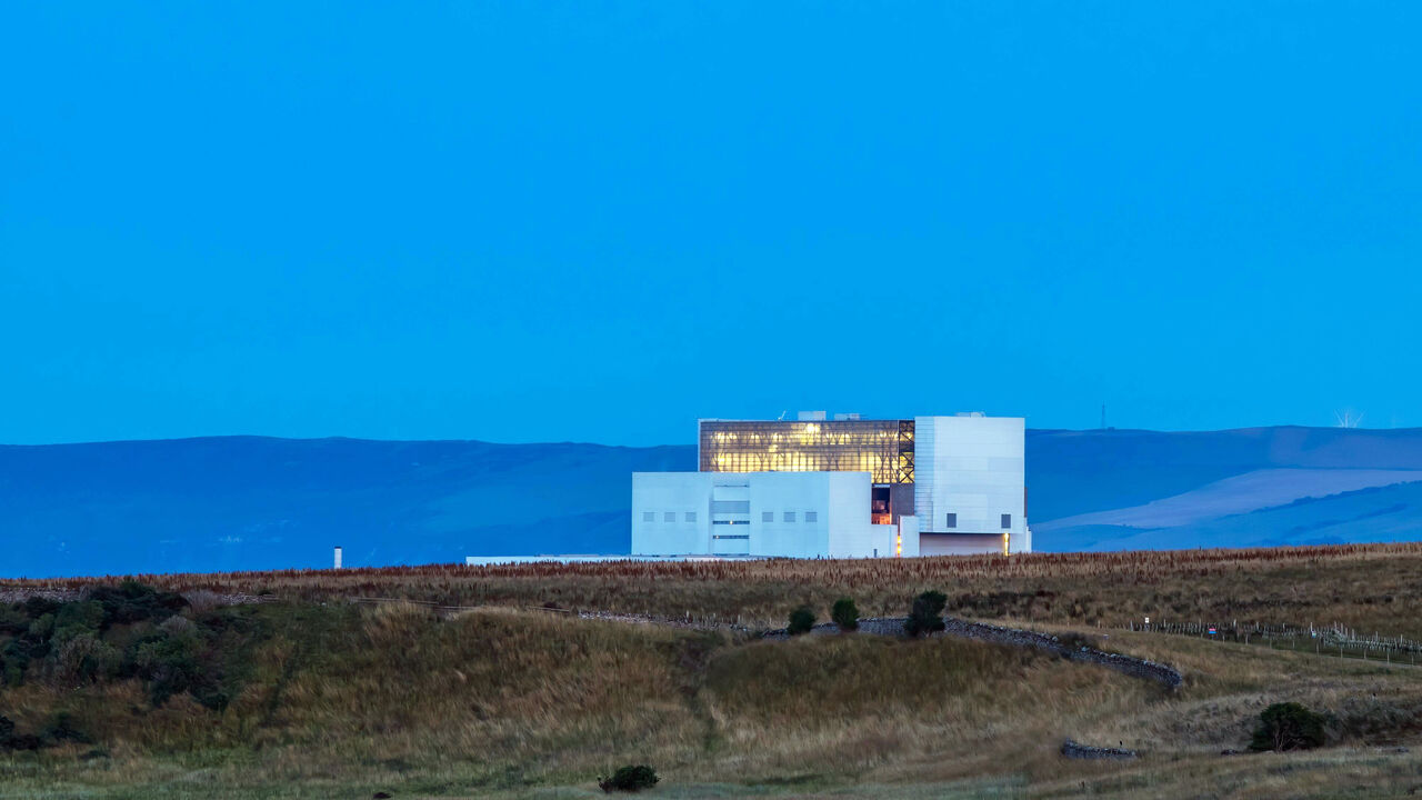 Torness nucelar power station lit up at dusk, in Scotland, UK.