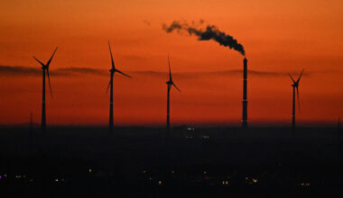 Wind turbines next to an industrial chimney near Duisburg, western Germany