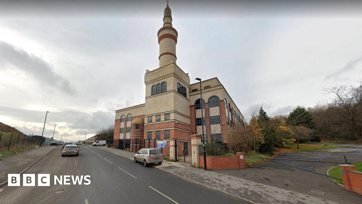 A large building with an ornate tower on the side of a road.