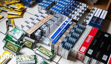 Numerous boxes of cigarettes and tobacco pouches scattered on the floor.