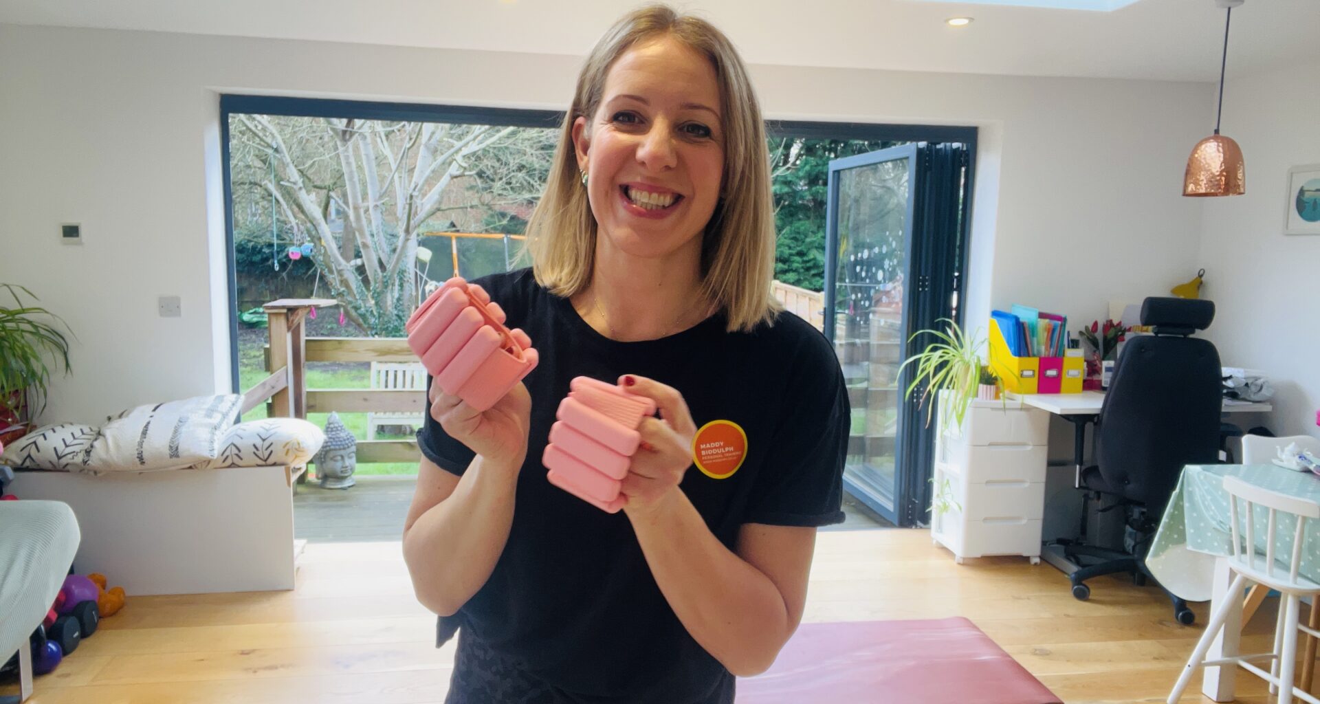 Woman holds pink wrist weights in her hands