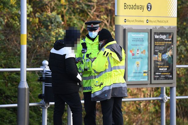 A fare dodger being spoken to by police and a Metrolink staff member