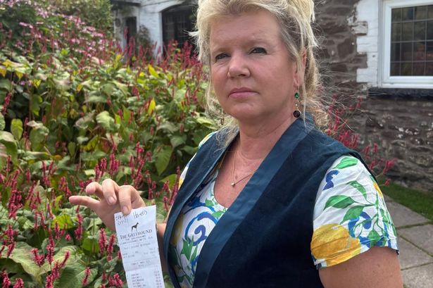 Kelly with the bill outside the pub