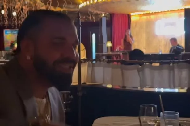 Drake was seen singing as he enjoyed a drink at a glamorous bar in Manchester city centre