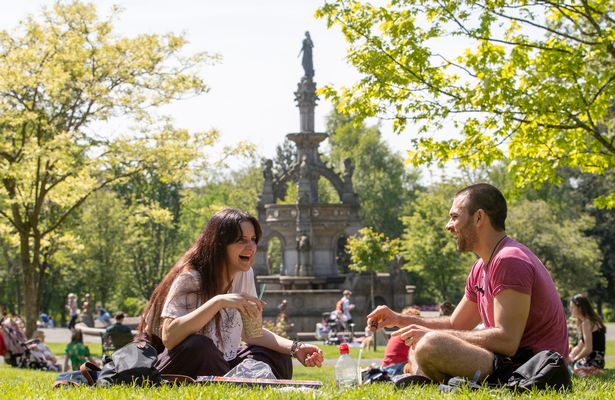 Students Iris Mandragouda (left) and Costas Spanachis enjoy the sunshine in Glasgow's Kelvingrove Park as the hot weather continues. 