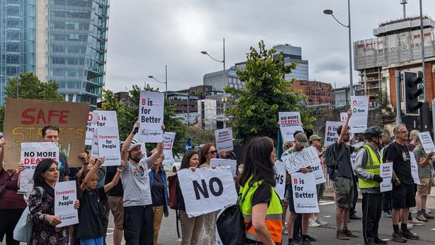Better Streets for Birmingham protesters hold signs as they stand in road during a protest event, 2024