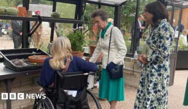 Princess Anne greeting a patient of the Princess Royal Spinal Injuries Centre, part of the Northern General Hospital, in the greenhouse of its new garden.