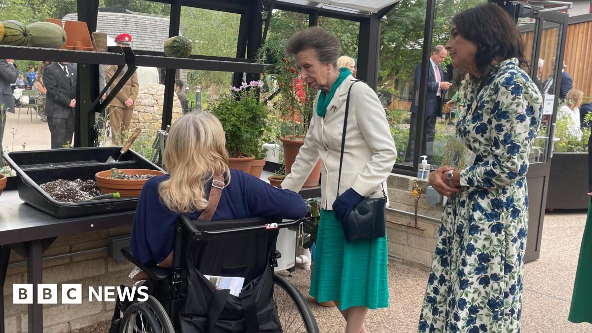 Princess Anne greeting a patient of the Princess Royal Spinal Injuries Centre, part of the Northern General Hospital, in the greenhouse of its new garden.