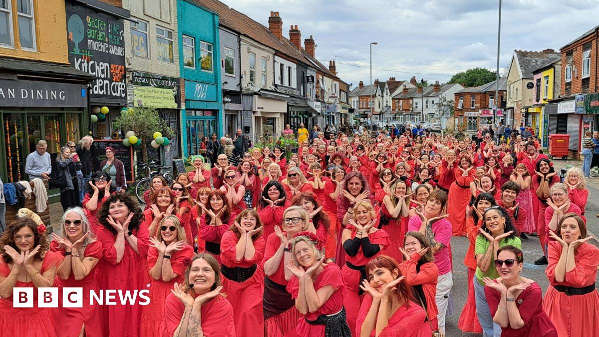 Dozens of women wearing red dance to Kate Bush's hit Wuthering Heights