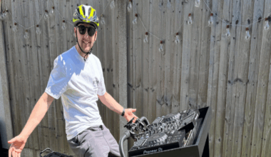 A man sitting on a bike with a DJ deck on the front of the bike.
