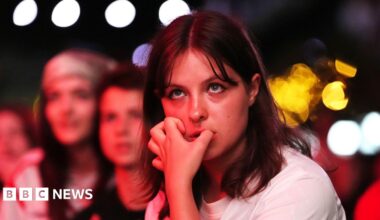A young woman with shoulder length brown hair and a fringe bites her nails in Boxpark Croydon during the semi-final between England and Italy