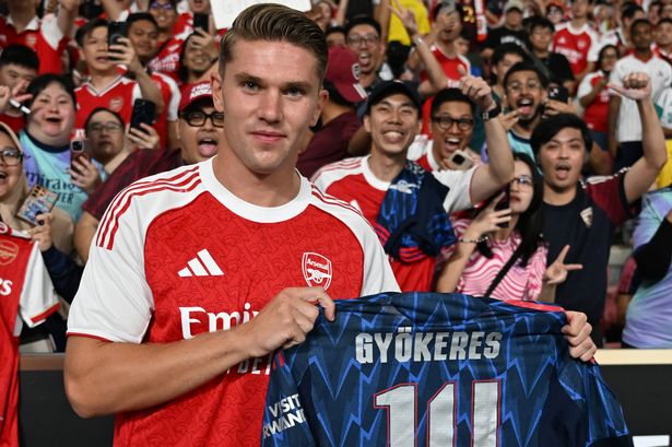 Viktor Gyokeres holds up the shirt in front of fans