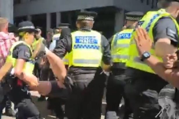 Police carry a protester away at a Palestine protest in St Peter's Square, manchester on July 12