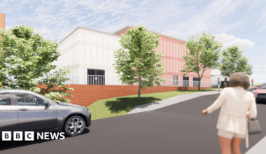 An artist's impression of the new building. A white-coloured building is directly next to an oak-coloured building. There are cars and trees in the foreground.