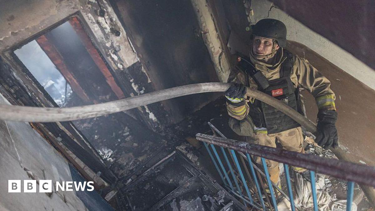 Ukrainian emergency service workers extinguish a fire in a residential building, after Russian shelling, in Kostiantynivka