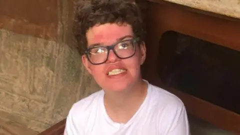 BBC Family photo of Fraser. He is wearing a white T-shirt and glasses