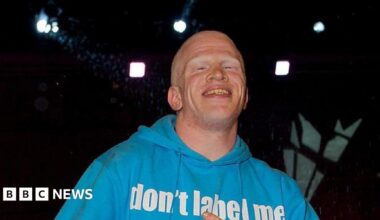 Darnell Swallow smiles as he as he is evicted from the Big Brother house. He wears a light blue hoodie.