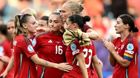 Getty Images Wales players on the pitch put their arms around each other after their 3-0 defeat by the Netherlands at Euro 2025.