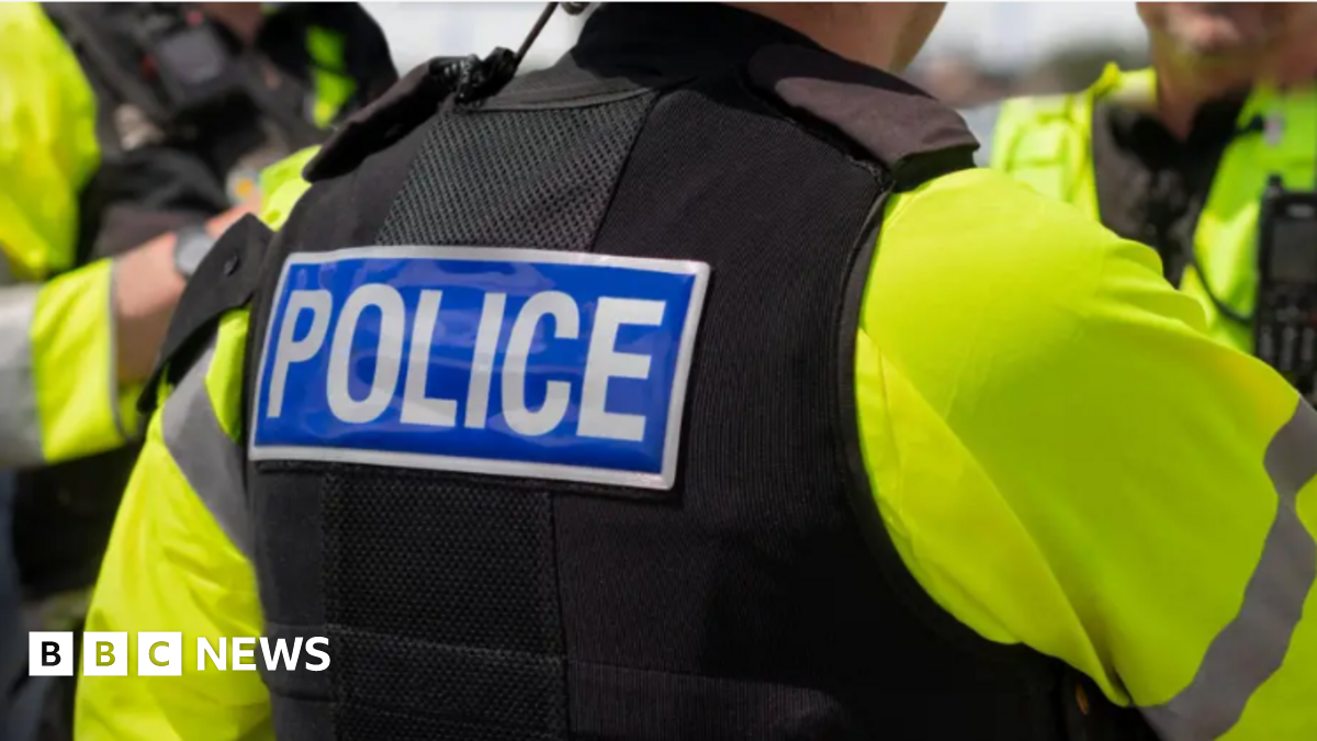 Shows police officers in flak jackets and yellow bibs